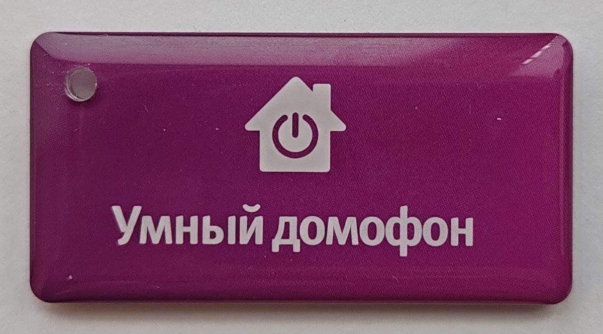 Оригинальный ключ Уфанета, лицевая сторона: фиолетовый брелок с домиком и надписью «Умный домофон»